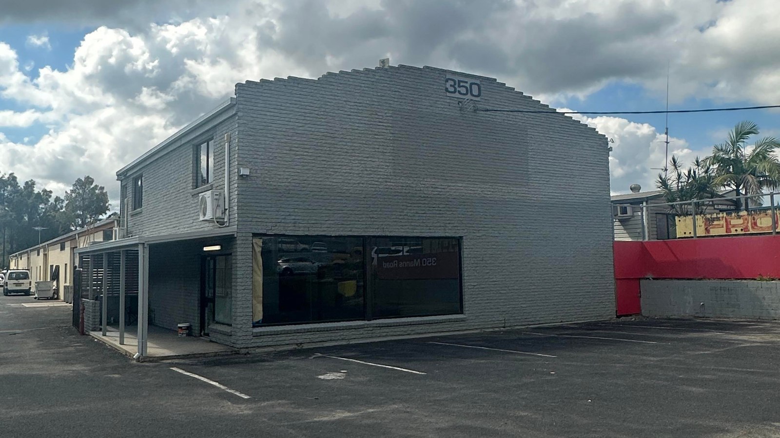 Retail premises exterior in tired grey paint before repainting