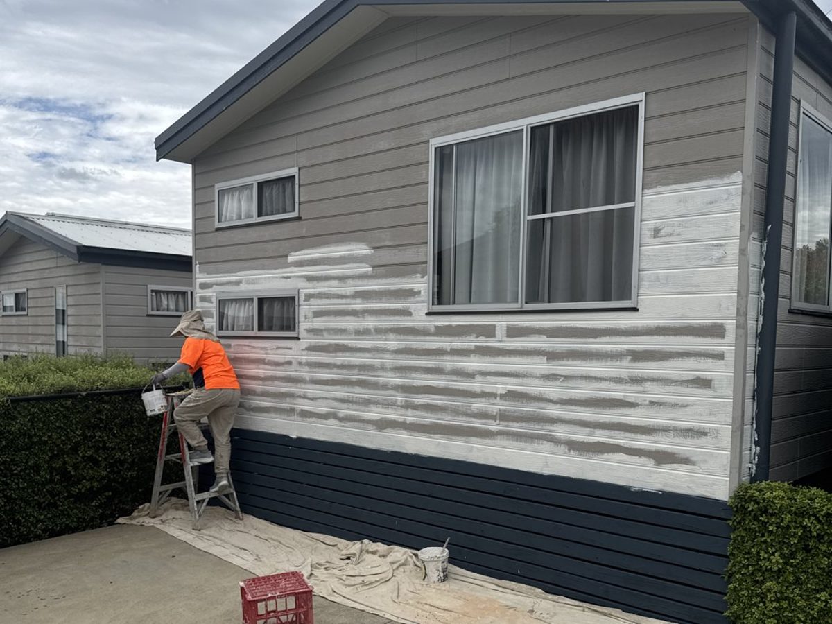 Premier Painting team member repainting a holiday park cabin exterior
