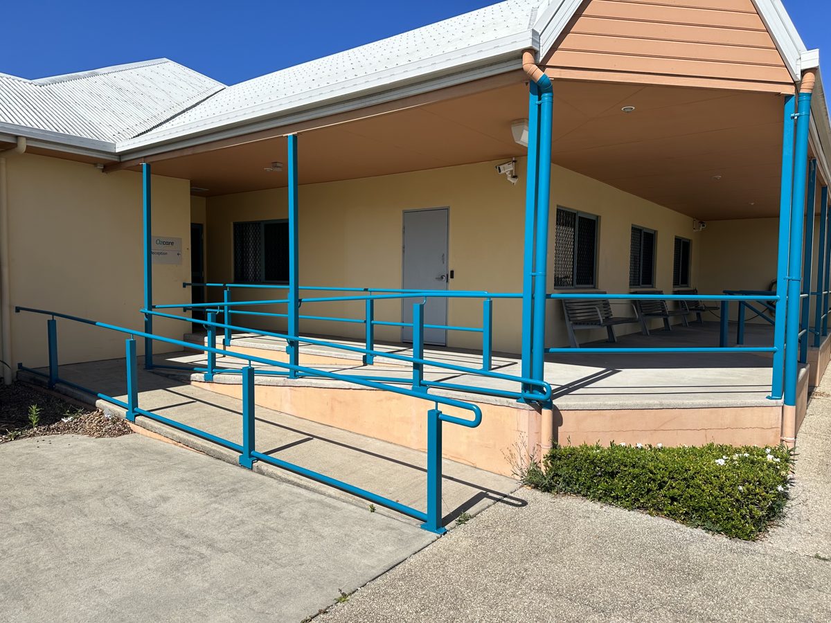 Repainted ramp handrails in fresh blue at a commercial facility