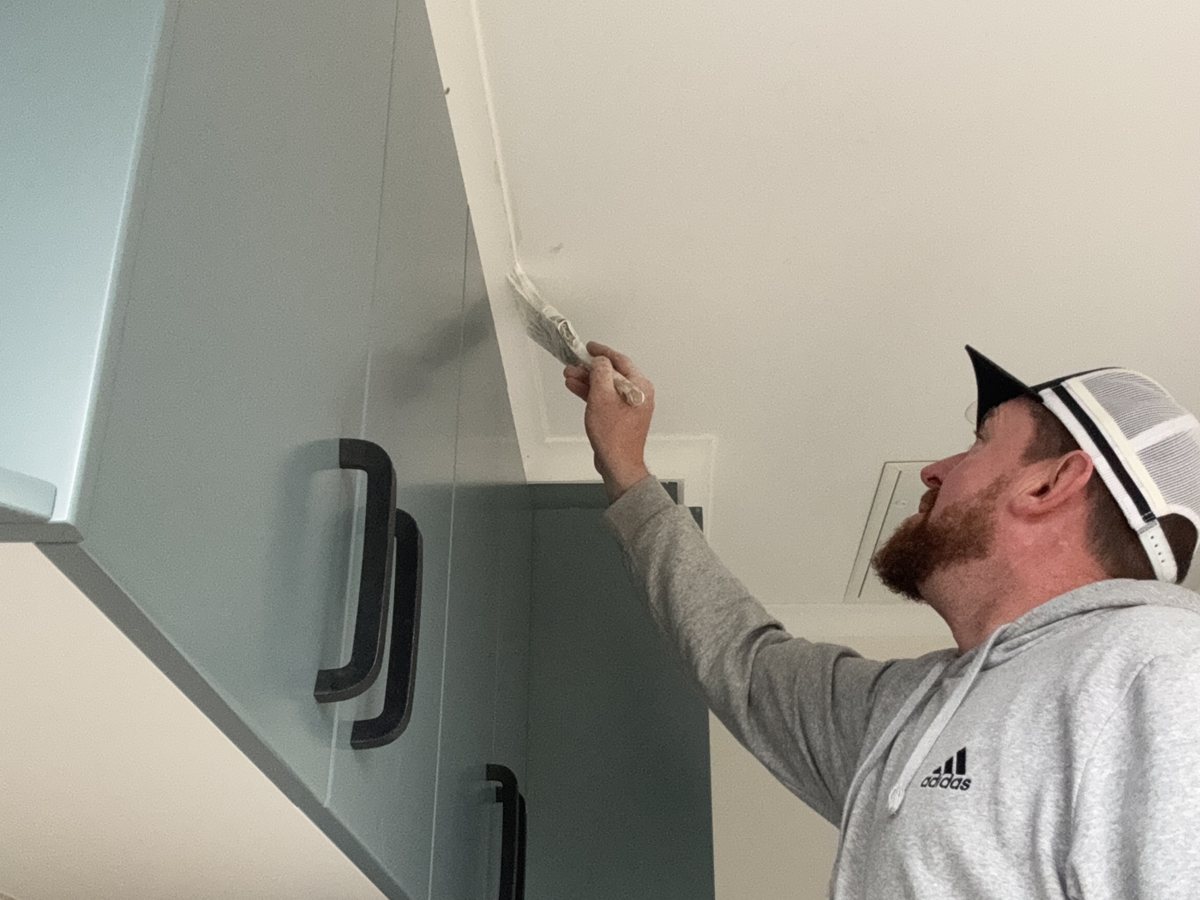 Jason Huntly cutting in a ceiling line on a Canberra interior repaint